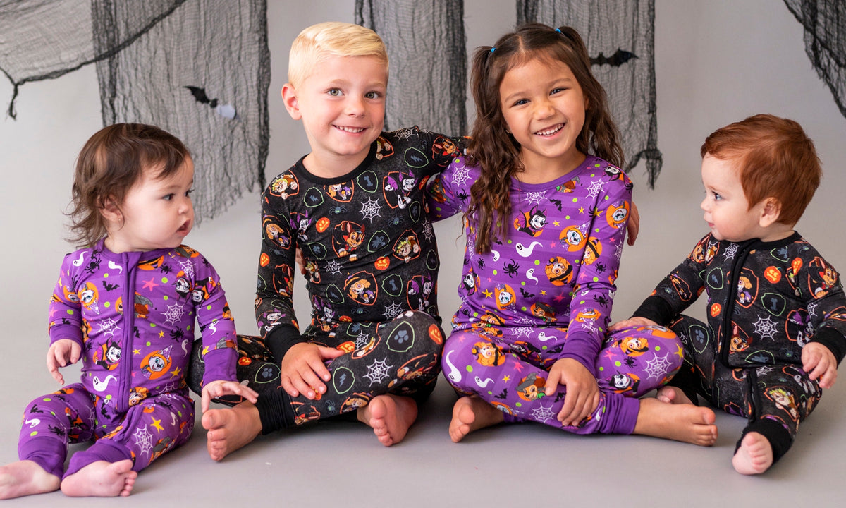Four kids in purple and black PAW Patrol Howl-o-ween Halloween jammies